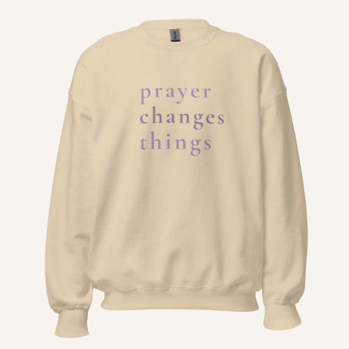 cream sweatshirt with 'Prayer Changes Things' purple text on a cream background