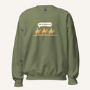 Green unisex crewneck sweatshirt featuring a gold desert scene with three camels and a speech bubble reading “Are we there yet?”