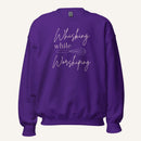 Purple crewneck sweatshirt with "Whisking while Worshiping" pink text with a pink whisk graphic.