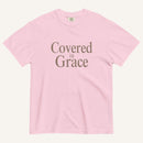 Pink t-shirt with 'Covered in Grace' text on a white background