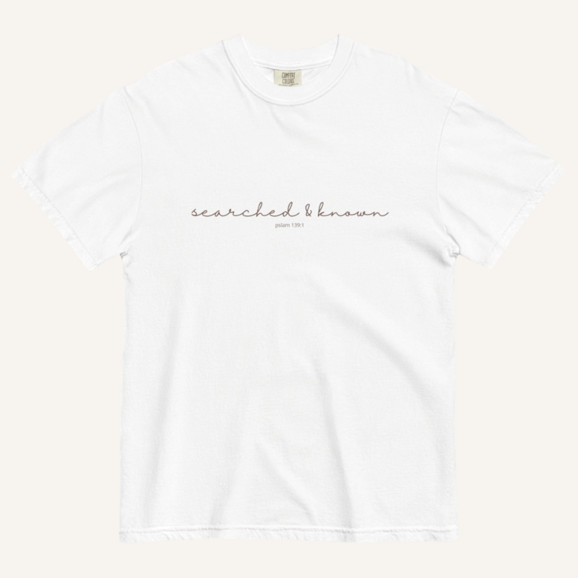 white t-shirt with 'Searched & Known' text on a cream background