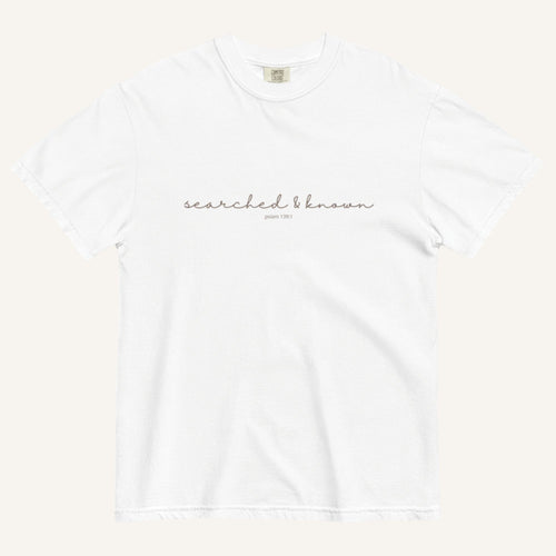 white t-shirt with 'Searched & Known' text on a cream background