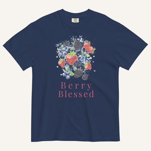 A navy blue short-sleeve t-shirt with a watercolor-style graphic of various berries (strawberries, blueberries, blackberries) and the text 'Berry Blessed' printed below it in pink, displayed on a light cream background.