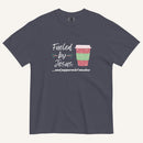 dark muted grey blue Christmas T-shirt featuring the phrase “Fueled by Jesus …and peppermint mochas” with a festive peppermint mocha cup design.