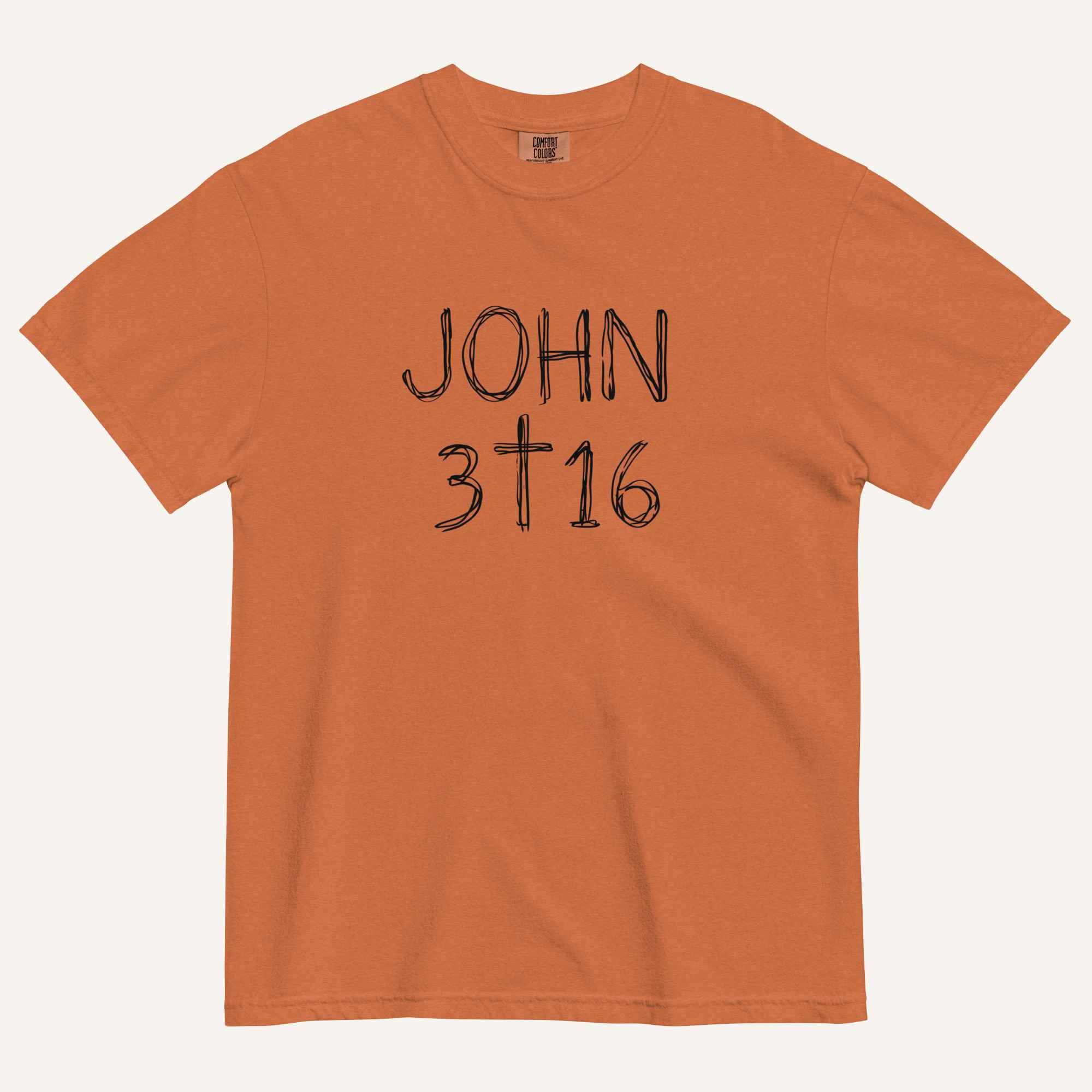 An orange short-sleeve crewneck t-shirt with 'JOHN 3 16' text with cross graphic in between the 3 & 16 printed in a black hand-drawn font on the chest, displayed flat against a light cream background.