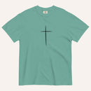 A short-sleeve crewneck t-shirt in a muted teal-green color, featuring a simple black Christian cross printed on the center chest. The t-shirt is laid flat against a solid, warm off-white background.