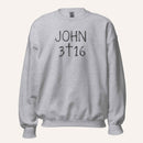 a light grey crewneck sweatshirt with 'John 3 16' text with cross graphic between the 3 & 16 on a light cream background