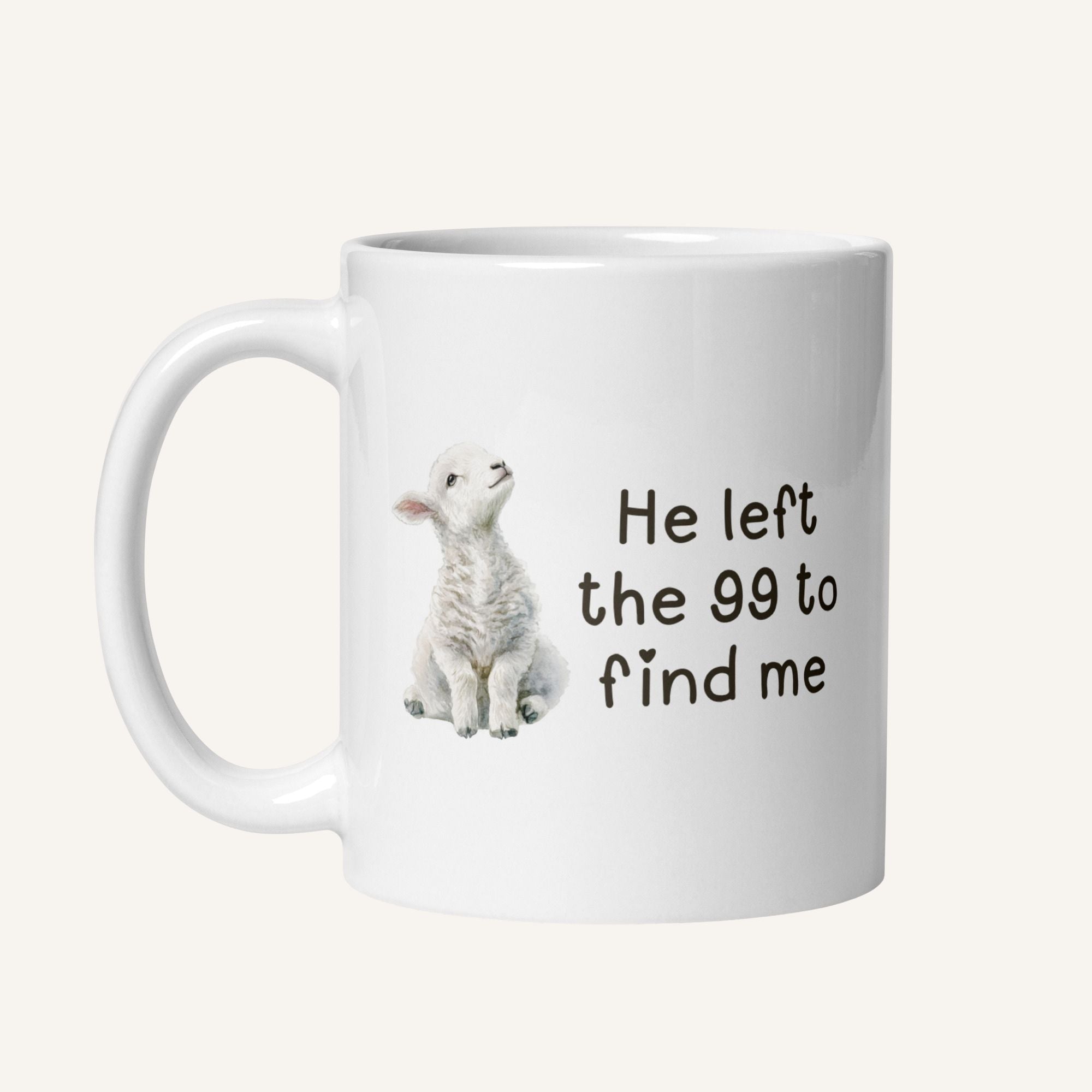 white 11 oz mug with a water color lamb and 'He left the 99 to find me' text on a cream background