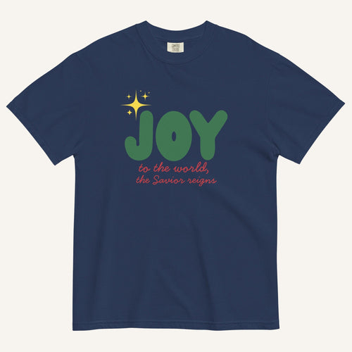 a navy t-shirt with the words "Joy to the world, the Savior reigns" in bold colorful font with a star graphic
