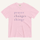 Pink t-shirt with 'prayer changes things' text on a white background