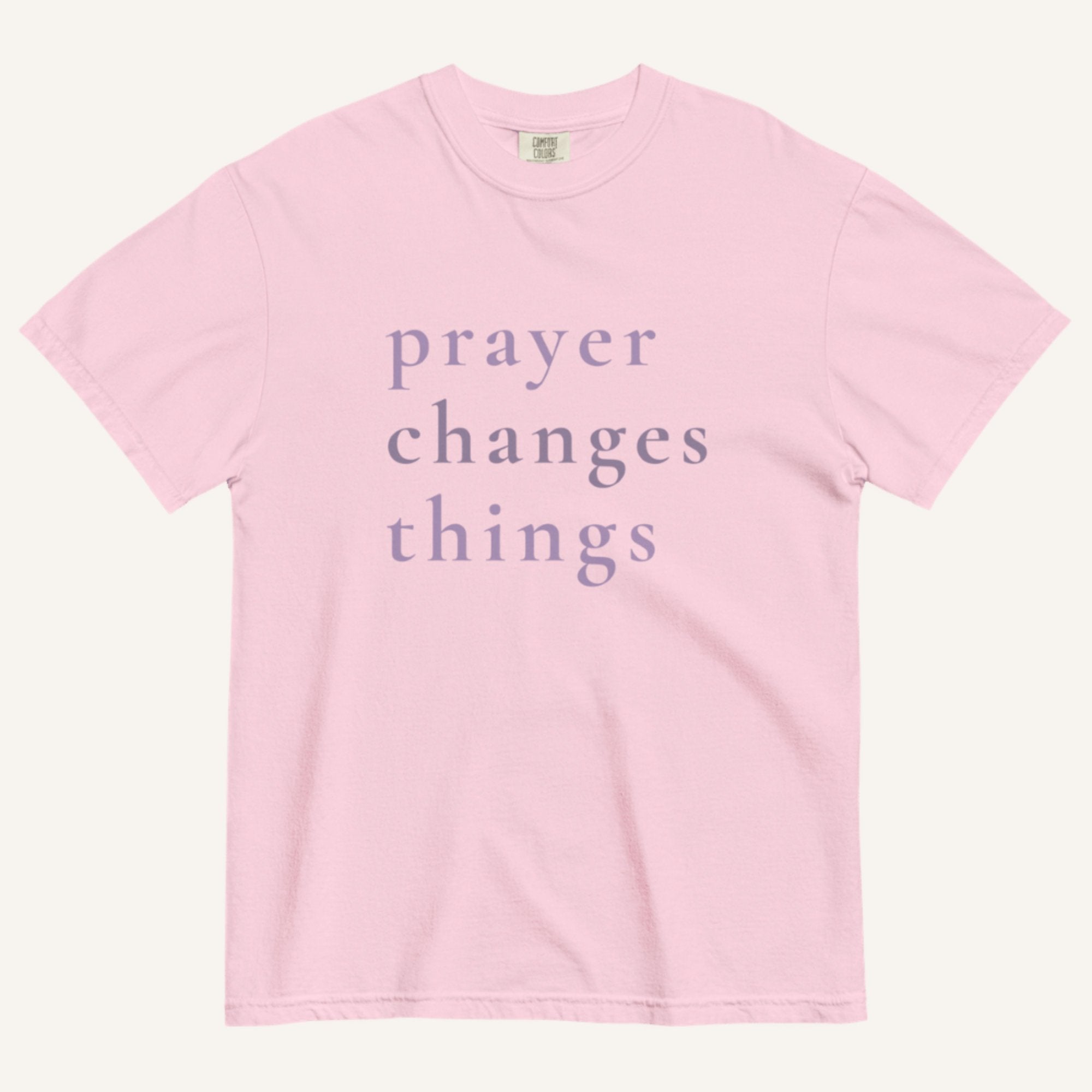 Pink t-shirt with 'prayer changes things' text on a white background