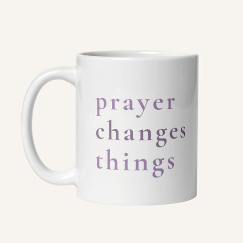 White 11 oz mug with 'prayer changes things' text in purple on a white background