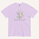 Lavender t-shirt with floral design and 'Matthew 6:28' text on a white background