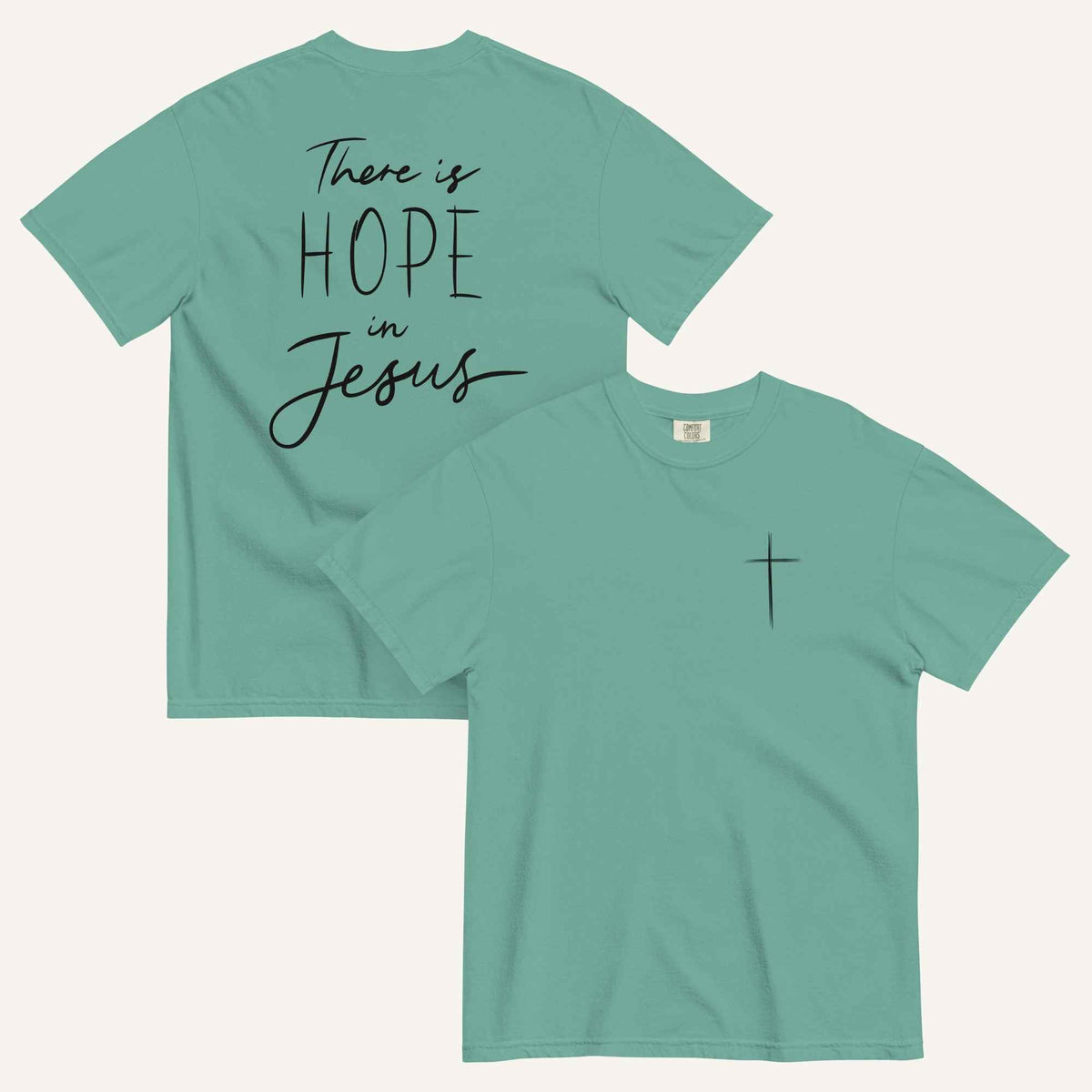 A seafoam green t-shirt shown from both the front and back. The front features a small black cross on the top left. The back features the black text 'There is HOPE in Jesus' in a mix of script and block lettering.