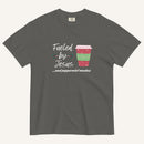 Grey Christmas T-shirt featuring the phrase “Fueled by Jesus …and peppermint mochas” with a festive peppermint mocha cup design.