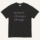 Black t-shirt with 'prayer changes things' text on a white background