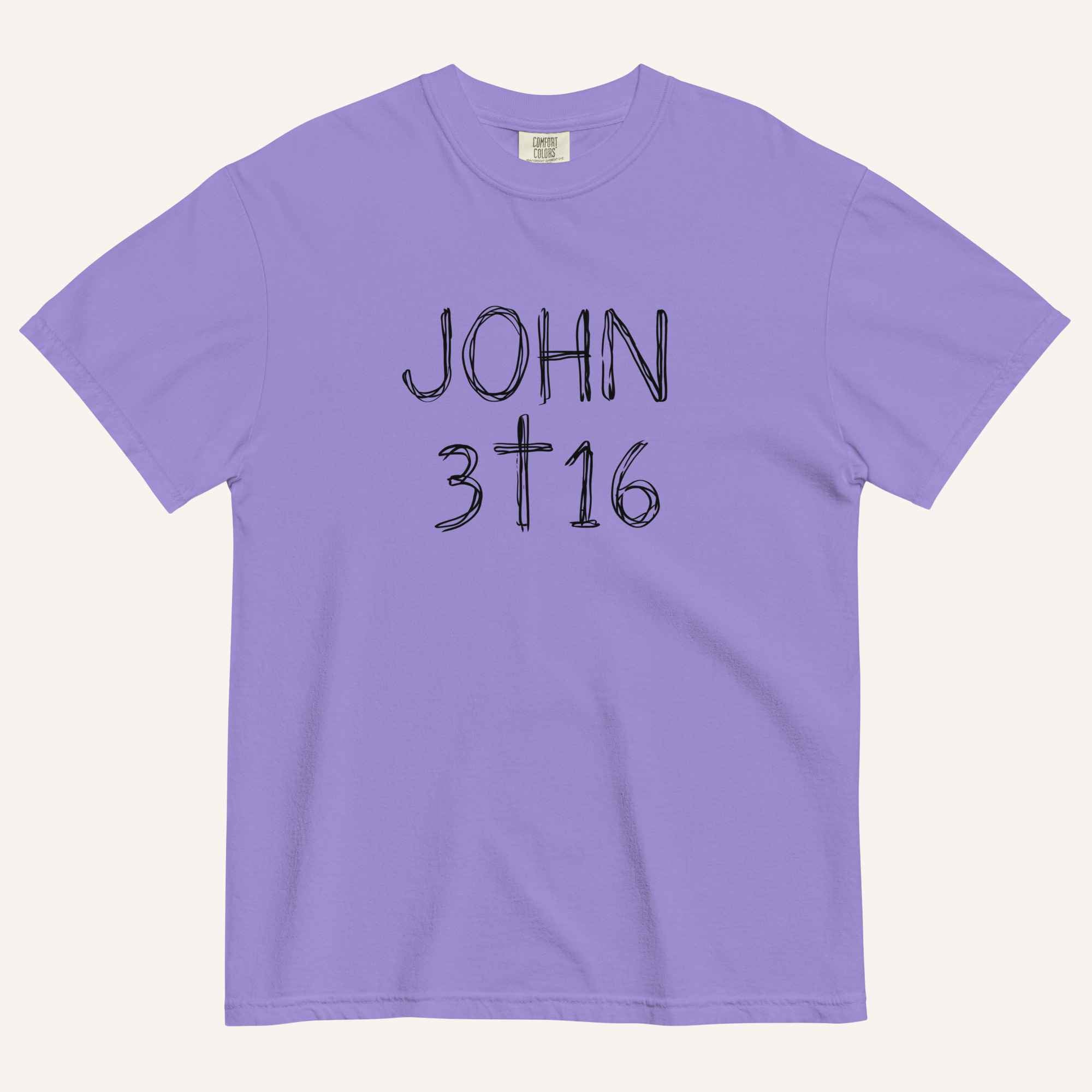 A lavender purple short-sleeve crewneck t-shirt with 'JOHN 3 16' text with cross graphic in between the 3 & 16 printed in a black hand-drawn font on the chest, displayed flat against a light cream background.