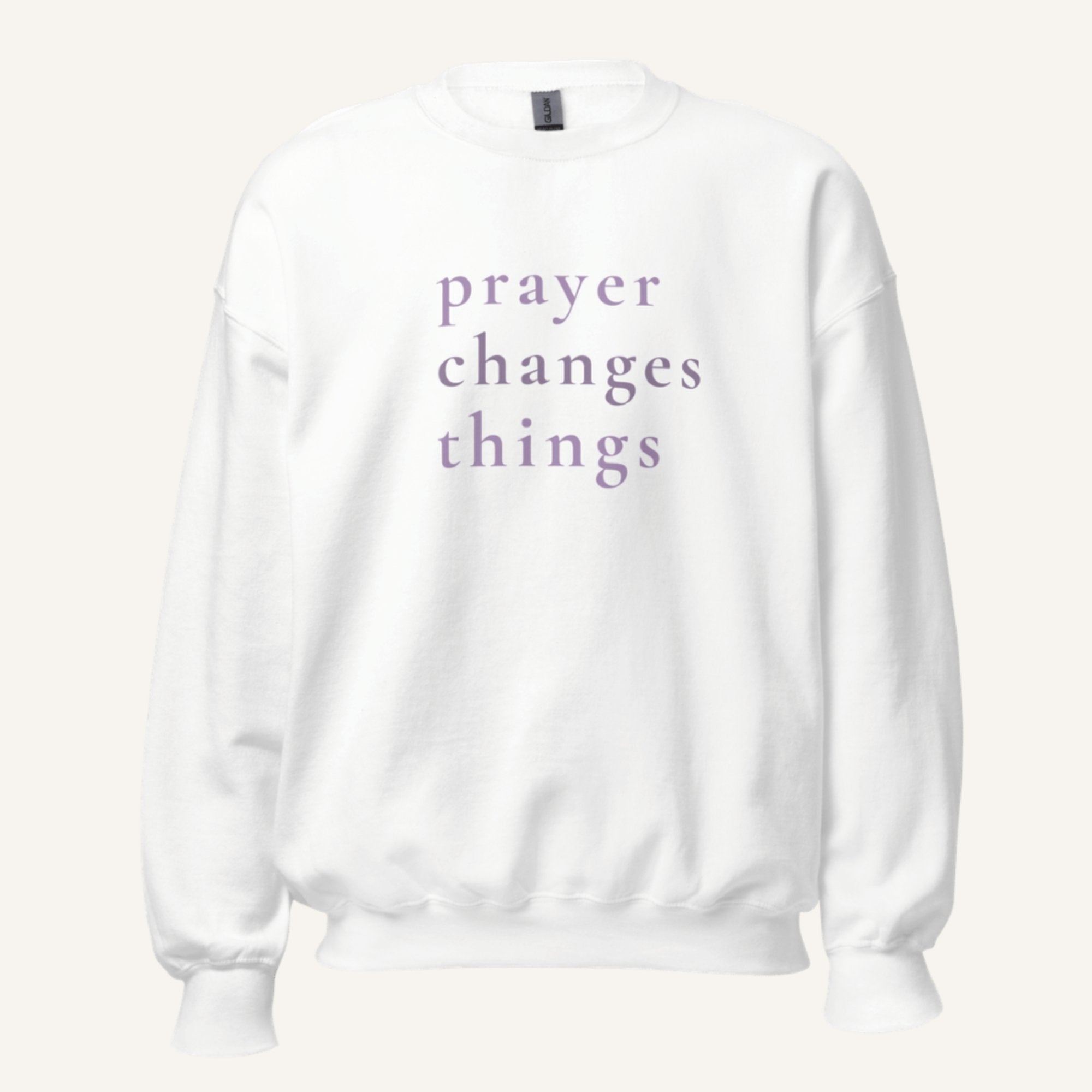 white sweatshirt with 'Prayer Changes Things' purple text on a cream background