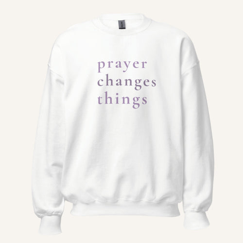 white sweatshirt with 'Prayer Changes Things' purple text on a cream background