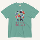 A mint green short-sleeve t-shirt with a colorful graphic of various berries (strawberries, blueberries, blackberries) and the text 'Berry Blessed' printed below it, displayed on a light cream background.