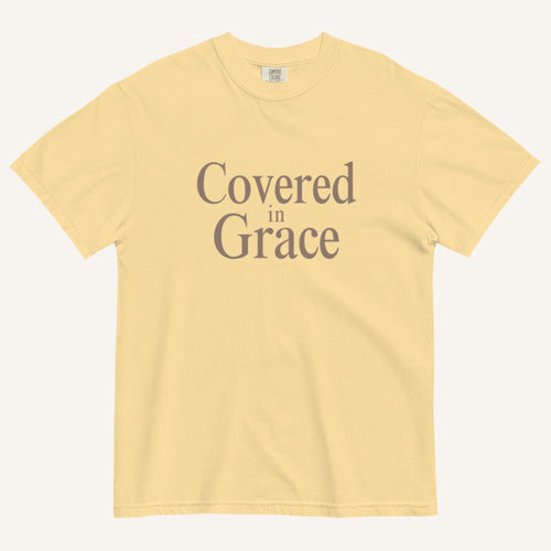 Yellow t-shirt with 'Covered in Grace' text on a white background