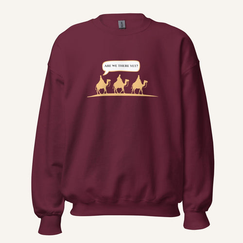Burgundy unisex crewneck sweatshirt featuring a gold desert scene with three camels and a speech bubble reading “Are we there yet?”