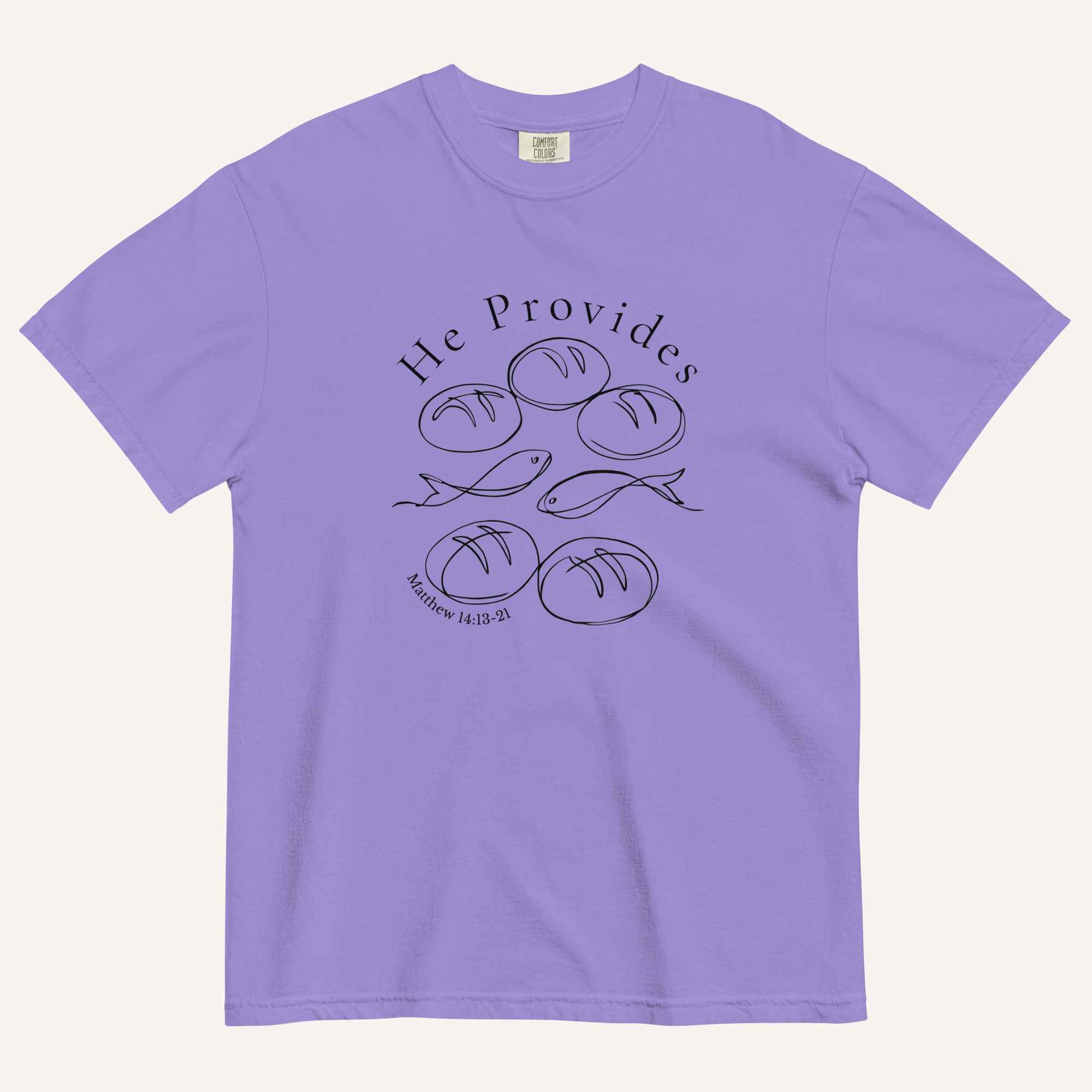 A purple short-sleeve t-shirt with a black graphic print on the front showing fish and loaves of bread, with the text 'He Provides' and 'Matthew 14:13-21'.