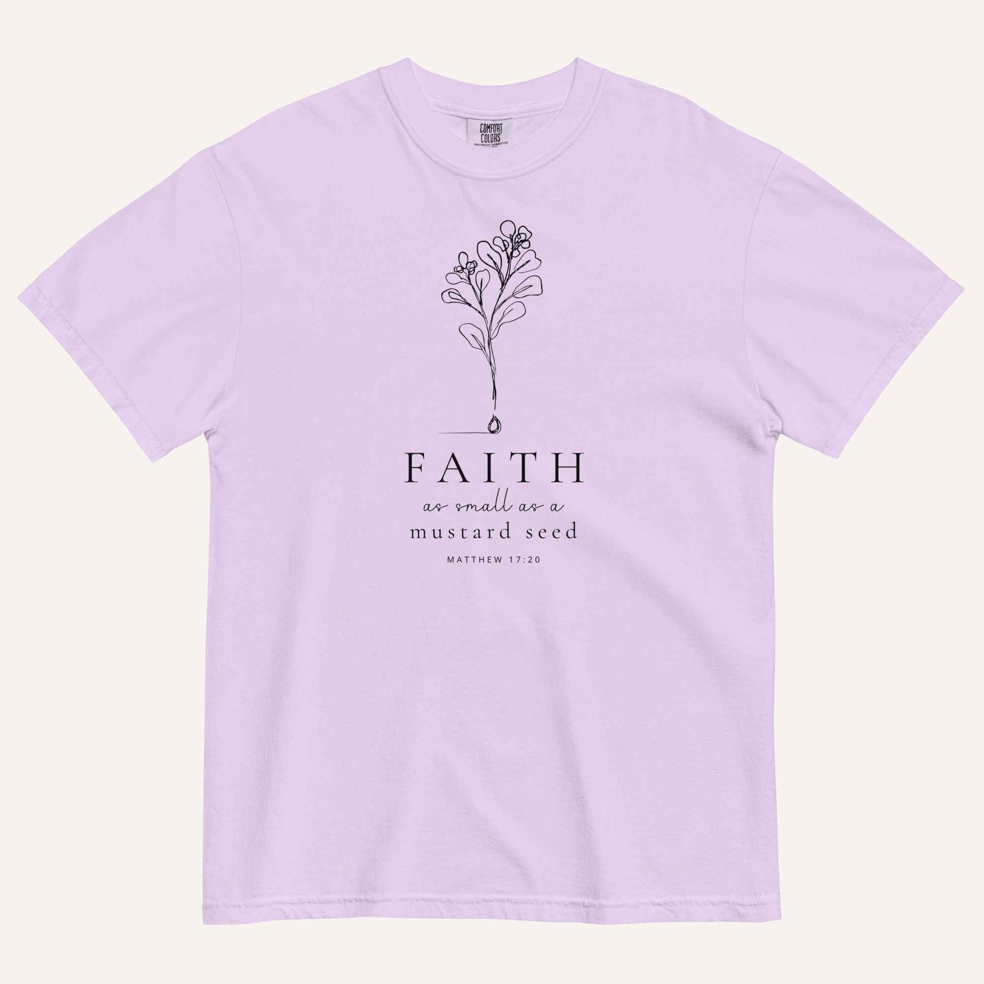 A light purple short-sleeve crewneck t-shirt with a black line-art mustard seed graphic and the text 'FAITH as small as a mustard seed' and 'MATTHEW 17:20' printed on the front, displayed against a light cream background.