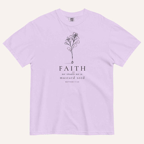 A light purple short-sleeve crewneck t-shirt with a black line-art mustard seed graphic and the text 'FAITH as small as a mustard seed' and 'MATTHEW 17:20' printed on the front, displayed against a light cream background.