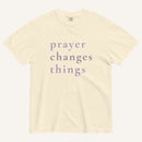Beige t-shirt with 'prayer changes things' text on a white background