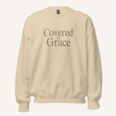 cream sweatshirt with 'Covered in Grace' text on a cream background