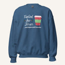 Blue unisex crewneck sweatshirt featuring a Christmas design with the phrase “Fueled by Jesus …and peppermint mochas,” peppermint illustrations, and a festive red and green peppermint mocha cup graphic.