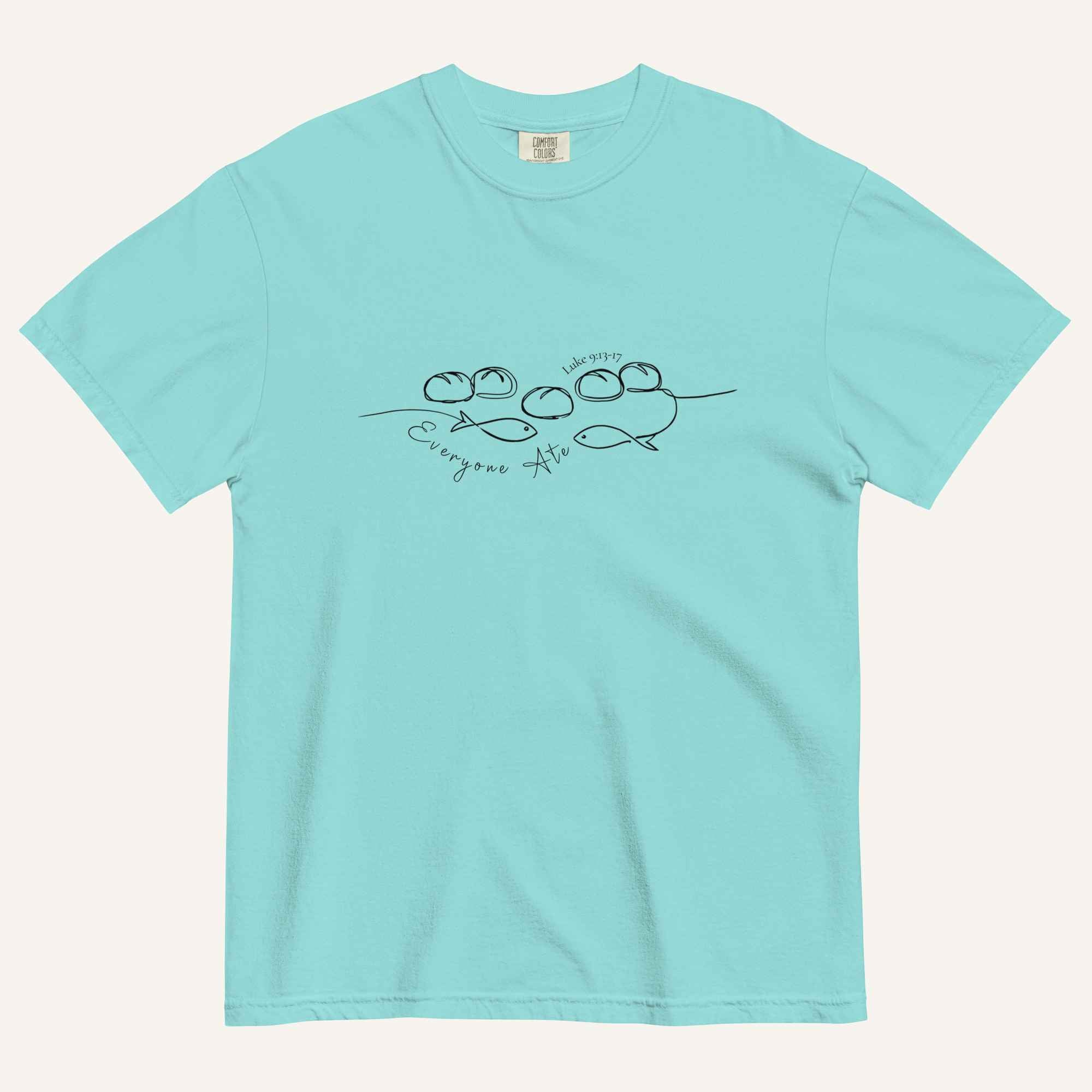 A light aqua blue short-sleeve crewneck t-shirt with a black graphic of two fish and 5 loaves of bread on a line and the cursive text 'Everyone Ate' across the chest, displayed flat against a light beige background.