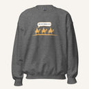 Grey heather unisex crewneck sweatshirt featuring a gold desert scene with three camels and a speech bubble reading “Are we there yet?”