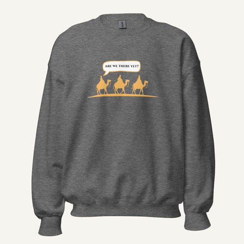 Grey heather unisex crewneck sweatshirt featuring a gold desert scene with three camels and a speech bubble reading “Are we there yet?”