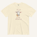 Ivory t-shirt with watercolor lamb and 'Found by the Shepherd' text on cream background