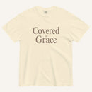 Beige t-shirt with 'Covered in Grace' text on a white background
