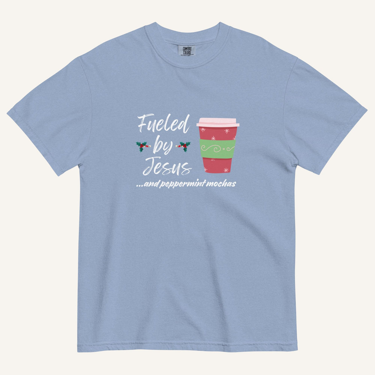 light blue Christmas T-shirt featuring the phrase “Fueled by Jesus …and peppermint mochas” with a festive peppermint mocha cup design.