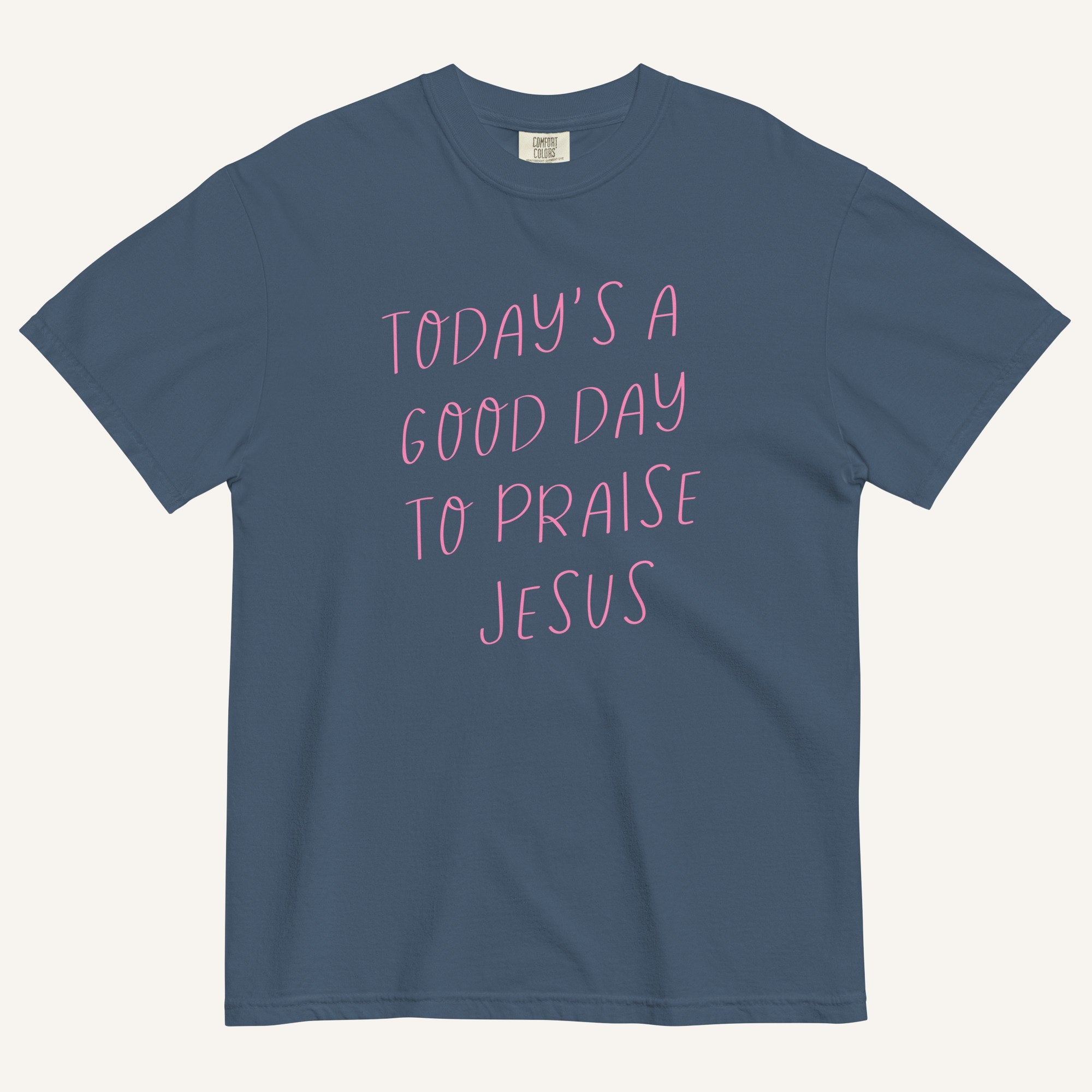muted blue t-shirt with 'Today's a Good Day to Praise Jesus' pink text on a cream background
