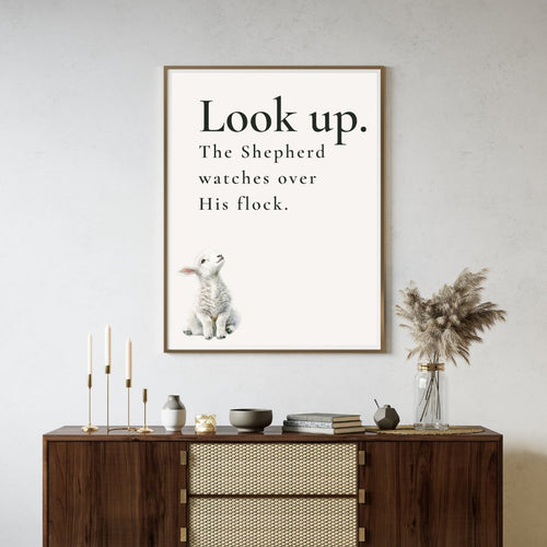 wall art featuring a watercolor lamb looking up with 'Look Up. The Shepherd watches over His flock' text in a neutral living room.
