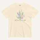 Beige t-shirt with floral design and 'Matthew 6:28' text on a white background