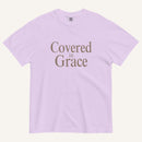 Lavender t-shirt with 'Covered in Grace' text on a white background