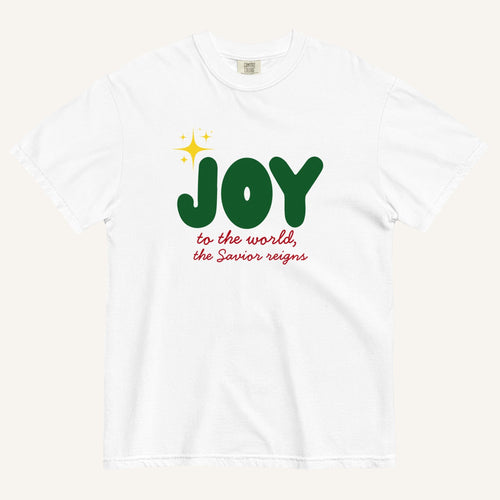 a white t-shirt with the words "Joy to the world, the Savior reigns" in bold colorful font with a star graphic