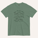 A sage green short-sleeve t-shirt with a black graphic print on the front showing fish and loaves of bread, with the text 'He Provides' and 'Matthew 14:13-21'.