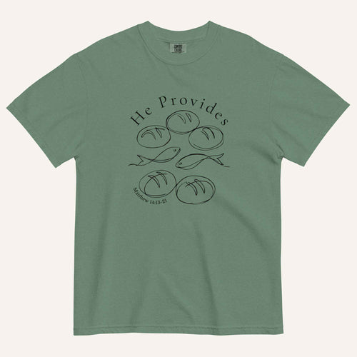 A sage green short-sleeve t-shirt with a black graphic print on the front showing fish and loaves of bread, with the text 'He Provides' and 'Matthew 14:13-21'.