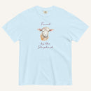 light blue t-shirt with watercolor lamb and 'Found by the Shepherd' text on cream background