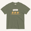 a green t-shirt with 3 men riding camels in the color yellow with a chat bubble with the text "are we there yet?"