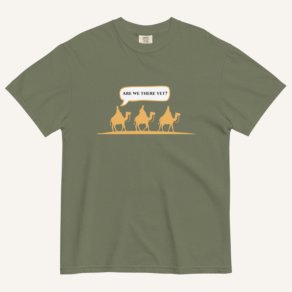 a green t-shirt with 3 men riding camels in the color yellow with a chat bubble with the text "are we there yet?"