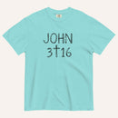 An aqua short-sleeve crewneck t-shirt with 'JOHN 3 16' text with cross graphic in between the 3 & 16 printed in a black hand-drawn font on the chest, displayed flat against a light cream background.