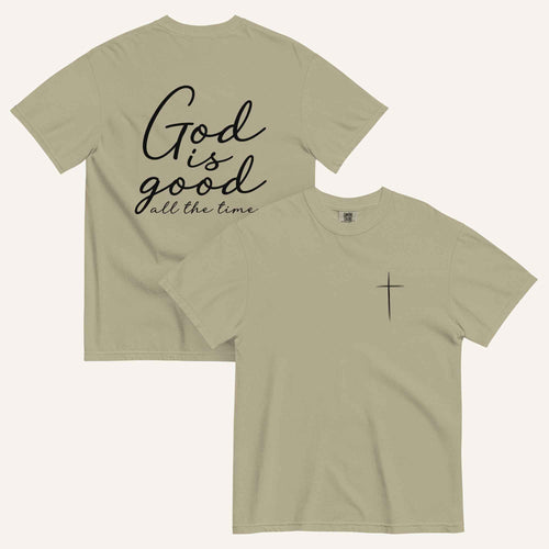A light army green short-sleeve t-shirt shown from both the front and back on a light cream background. The back features the phrase 'God is good all the time' in black script, and the front has a small black cross on the left chest.